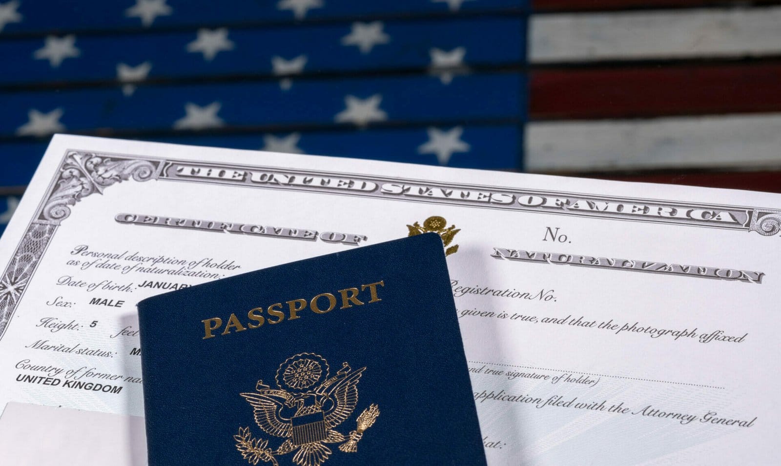 USA passport and Naturalization Certificate of citizenship over background of a wooden US Stars and Stripes flag